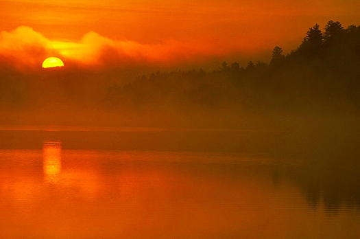Red sunset over misty lake scene