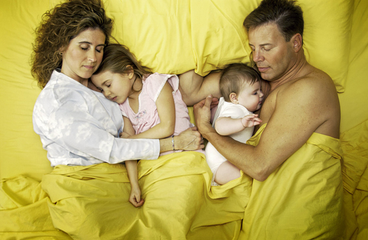 Family lying in bed