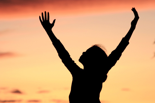 Silhouette of young girl dancing at sunset