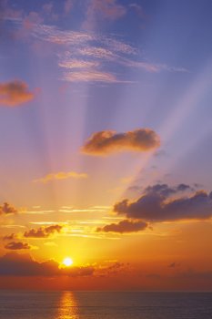 A golden sunset with rays against a blue sky