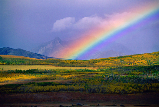 Large rainbow over Fall-colored mountain