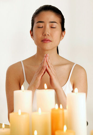 Praying young woman with candles