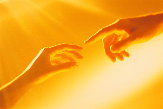 Two hands almost touching each other in a golden glow