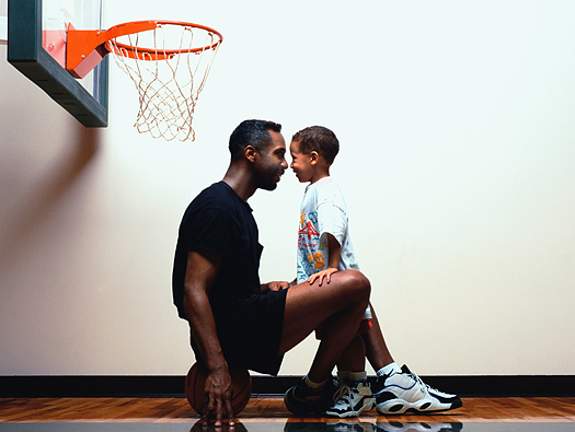 Father and young son on basketball court