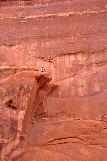 Man on a pink rock ledge by Don Paulson 
