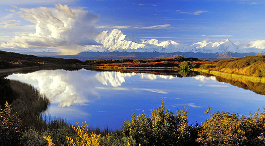 Still lake with mountains and clouds in the background
