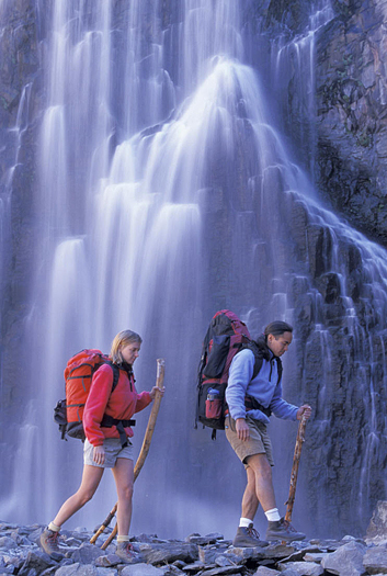 Couple hiking by a cascading waterfall