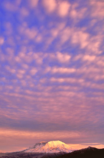 Mountain sky with interesting cloud formations in pink and blue