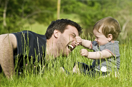cute little child joking outdoors with dad