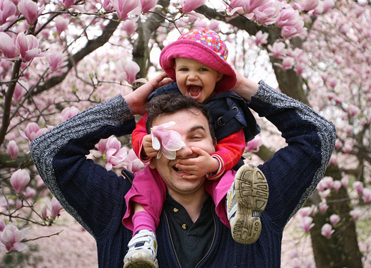 father and daughter play in a garden - spring