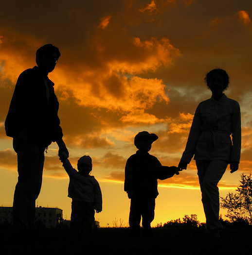 family of four silhouetted against a sunset sky