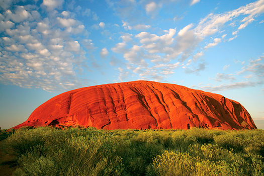 Uluru (Ayers Rock) early in the morning as the sun turns it bright red.