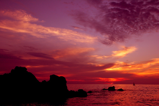 A dramatic ocean sunset in red and purple