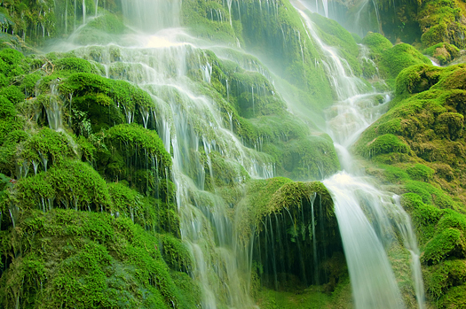 Waterfall over green mossy rocks