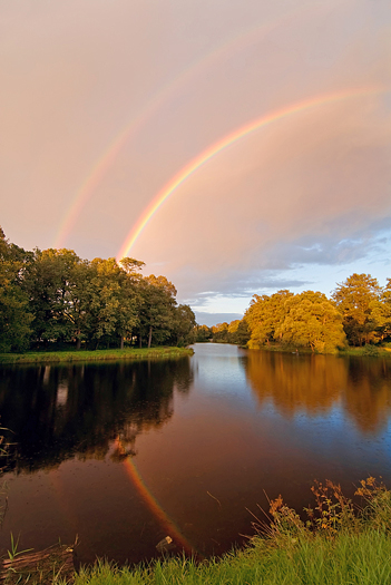 double reflected rainbow over autumn pond