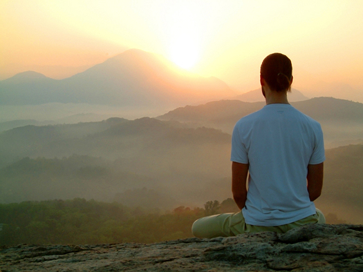 man meditating at mountain sunrise