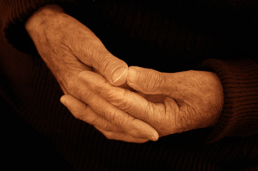 The calm composed hands of an 80 year old woman. Black and white sepia toned.