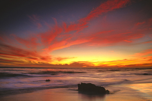 brooding beach sunset in red and yellow at el matador beach near malibu california usa north america