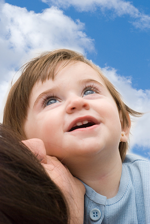 Smiling girl with mother looking upwards.