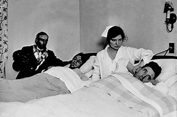 Hildah Hairgrove sitting between two men lying in beds in a hospital room in Chicago, Illinois [Library of Congress. DN-0089710]